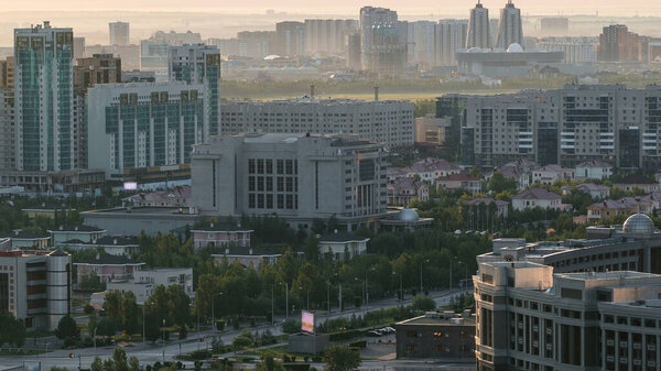 Elevated morning view over the city center and central business district aerial timelapse during sunrise time with mist, Nur-Sultan city, Kazakhstan, Central Asia