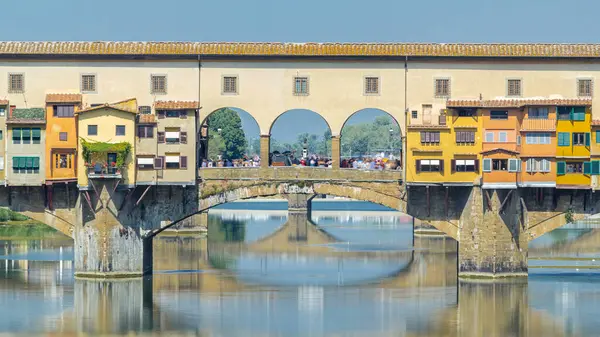 İtalya 'nın Floransa kentinde, Arno Nehri üzerindeki bir ortaçağ taş segmentli kemer köprüsü olan güneşli bir günde yapılan Ponte Vecchio, bir zamanlar yaygın olduğu gibi hâlâ üzerinde mağazalar inşa etmesiyle tanınıyor. Kapat.