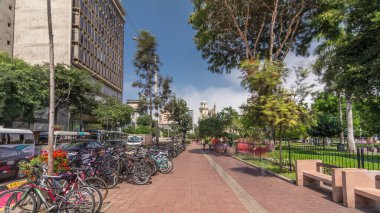 Jose Larco Bulvarı 'nda kırmızı bisiklet pisti ve Miraflores, Lima Peru' da bisiklet parkında hız sınırı. Central Park sağda ve caddede trafik var.