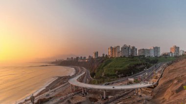 Miraflores civarındaki Lima 's Coastline' ın günbatımında turuncu ışıkla çekilmiş hava görüntüsü, Lima Peru. Husares De Junin rıhtımından okyanusla kesişen yol ve sahil trafiği