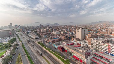 Via Expresa otoyolu ve Peru Ulusal Stadyumu yakınlarındaki trafikli metropol panoramik manzarası. Evler ve şehrin arka planında dağlar olan silueti. Lima, Peru