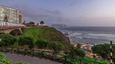 Villena Köprüsü 'nde trafik ve kısmi şehir manzarası var. Günbekten geceye geçiş zamanı, Lima, Peru. Aşk parkından aydınlık kıyı şeridi manzarası