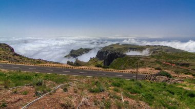 Pico do Arieiro, Madeira ve Portekiz 'in yamaçlarından bulutların üzerinden hava manzarası. Sisin yukarısına bak. Önünde yol var.