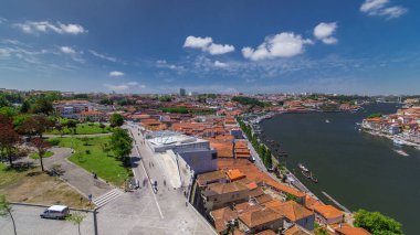 Aerial view over red roofs of the historic city of Porto, Portugal with the park timelapse with blue sky. Waterfront with red roofs