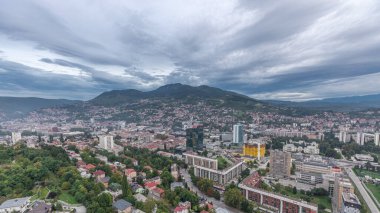 Aerial view of the southern part of Sarajevo city day to night transition. Skyline with skyscrapers and mountains from tallest tower viewpoint after sunset. Bosnia and Herzegovina, Southeast Europe. clipart