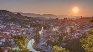 Saraybosna 'nın en popüler panoramik noktasından nehrin aktığı gün batımı manzarası. Sarı Kale (Zuta Tabija) yakınlarındaki yol, Vratnik