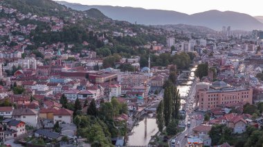 Saraybosna 'nın şehir manzarası, Saraybosna' nın en popüler panoramik noktasından gece geçiş dönemine kadar olan nehir manzarası. Sarı Kale (Zuta Tabija) yakınlarındaki yol, Vratnik