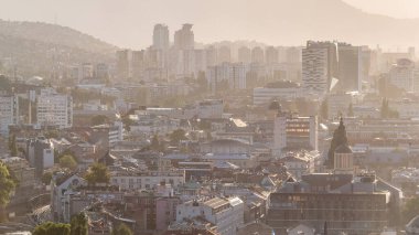 Bosna-Hersek 'in tarihi Saraybosna şehir merkezinin panoramik hava manzarası, ünlü binalar ve gün batımından önce puslu havayla çevrili