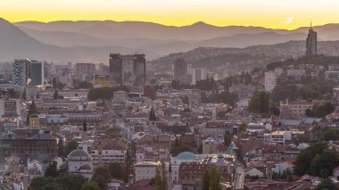 Saraybosna 'nın şehir manzarası, Saraybosna' nın en popüler panoramik noktasından gece geçiş dönemine kadar olan nehir manzarası. Sarı Kale (Zuta Tabija) yakınlarındaki yol, Vratnik