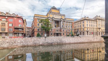 The Rectorate and Law School Building in Sarajevo timelapse hyperlapse. University building reflected in Miljacka river clipart