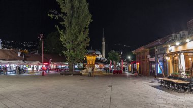 Fast walk from the Sebilj fountain to Ferhadija pedestrian street in Sarajevo old city in Bosnia and Herzegovina night hyperlapse. Run near many shops, restaurants and sightseeing on illuminated roads clipart