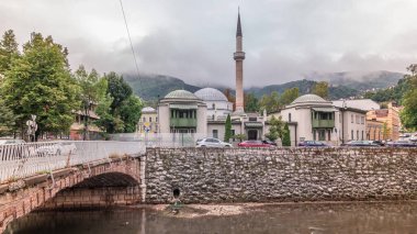 Beautiful view of the Emperor's Mosque in Sarajevo on the banks of the Milyacka River timelapse hyperlapse, Bosnia and Herzegovina. Mountains with clouds on a background clipart