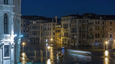 Grand Canal in Venice night timelapse, Italy. View on gondolas and city lights from Rialto Bridge. Beautiful and romantic Italian city on water from above