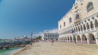 Waterfront and Palazzo Ducale (Doge's Palace) and Columns of San Marco and San Todaro from embankment timelapse hyperlapse, Venice, Italy. Blue cloudy sky at summer day clipart
