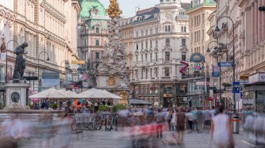 Graben Caddesi 'nde Viyana' nın ana caddesinde birçok dükkan ve restoran bulunan insanlar yürüyor. Pestsaule adındaki sütun, son büyük salgın hastalığın sona ermesinden sonra açıldı.