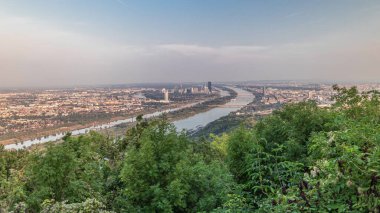Tuna Bakış Açısı Leopoldsberg 'in zaman çizelgesinden Viyana silueti. Nehir üzerindeki köprüler, gökdelenler ve tarihi binalar akşam olmadan önce.