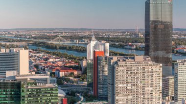 Donau City gökdelenleri, tarihi binaları ve Avusturya 'da nehir kenarındaki gezinti saatleriyle Viyana' nın panoramik manzarası. Tuna Kulesi 'nden gün batımından önce akşam silüeti