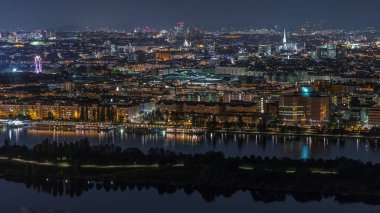 Viyana üzerinde gökdelenler, tarihi binalar ve Avusturya 'da nehir kenarında bir gece gezintisi ile hava panoramik manzarası. Tuna Kulesi perspektifinden aydınlatılmış gökyüzü