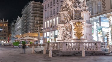 Graben Caddesi 'nde insanlar yürüyor. Viyana' nın eski ana caddesinde Avusturya 'da birçok dükkan ve restoran var. Pestsaule adındaki sütun, son büyük salgından sonra açıldı.