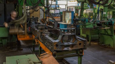 Konveyör montajı, traktörün gövdesini büyük endüstriyel fabrika zaman diliminde sahneleyecek. Çerçeve montajı kızgın perçinli metal bir masa üzerinde