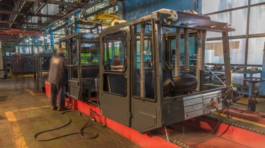 Konveyör montajı, traktörün gövdesini büyük endüstriyel fabrika zaman diliminde sahneleyecek. Kabin montajı, montaj parçaları ve kapı camları