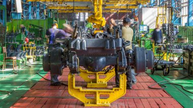 Konveyör montajı, traktörün gövdesini büyük endüstriyel fabrika zaman diliminde sahneleyecek. Çerçeve montajı, çamurluk kurulumu ve diğer bölümler.