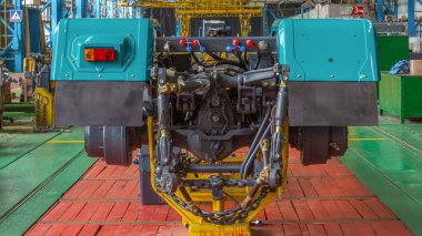 Konveyör montajı, traktörün gövdesini büyük endüstriyel fabrika zaman diliminde sahneleyecek. Çerçeve montajı, arka ışık kurulumu ve diğer bölümler.