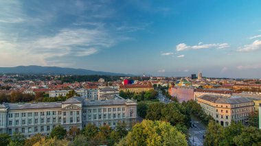 Şehir merkezinin panoraması, gün batımından sonra Hırvatistan 'ın Zagreb kentindeki ulusal tiyatro ve müzenin önündeki kavşağa hava manzaralı gökdelenin tepesinden gece gündüz geçiş zamanlaması kaydediliyor