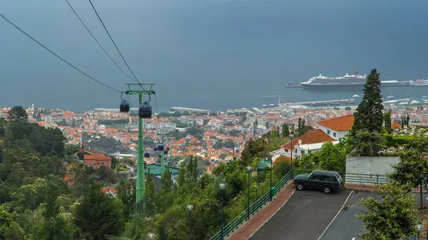 Madeira zaman diliminde teleferikli hava manzaralı. Limanda çatıları olan bir gemiyle okyanusa genel bir bakış. Modern peyzaj. Funchal, Portekiz.