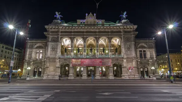 stock image Beautiful view of Wiener Staatsoper (Vienna State Opera) night timelapse hyperlapse in Vienna, Austria. Illuminated historic buildings and traffic on streets
