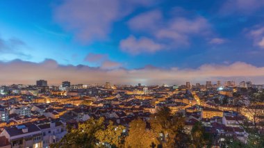 Panorama showing aerial view of downtown of Lisbon day to night transition timelapse, Portugal. Red roofs of typical houses in old town skyline. Historical district after sunset in capital city clipart