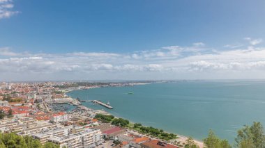 Panorama showing aerial view of marina and city center timelapse in Setubal, Portugal. Red roofs and waterfront with boats and ships from above. Cloudy sky at sunny day clipart