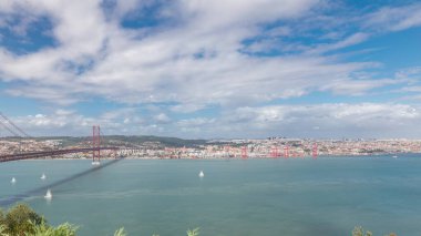 Lizbon şehir manzarası ve Tagus Nehri zaman çizelgesini gösteren panorama, Almada 'daki Cristo Rei' nin bakış açısından tarihi 25 Nisan köprüsü ile Eski Şehir Alfama 'nın hava manzarası. Portekiz