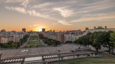 Panorama showing sunset over lawn at Alameda Dom Afonso Henriques with colorful buildings and the Luminous Fountain aerial timelapse. View from above with evening sky in Lisbon, Portugal clipart