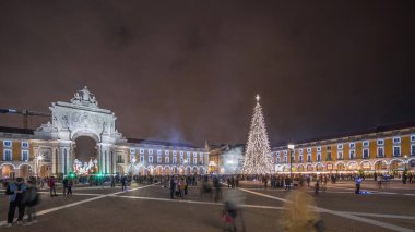 Panorama, Ticaret Meydanı 'nın ışıklandırılmış kemerini ve Lizbon' da Noel zamanında süslenmiş halini gösteriyor. Noel ağacı ve insanların toplandığı bir meydan. Tatil zamanları. Portekiz