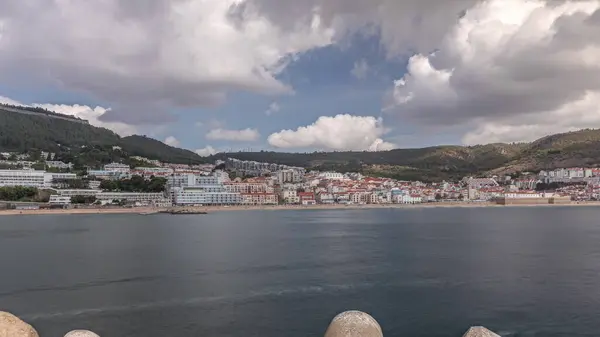 stock image Panorama showing view of Sesimbra Town and Port timelapse, Portugal. Skyline landscape with boats, houses and beach from lighthouse on a pier. Resort in Setubal district