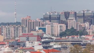 Amoreiras alışveriş merkezi kuleleriyle Lizbon 'un gökyüzü manzarası. Miradouro da Graca 'dan yeşil ağaçlar ve TV anten kulesi zaman ayarlı tarihi binalar bölgesi. Lizbon, Portekiz