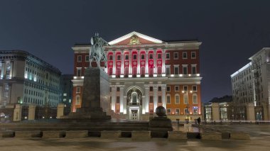 Moskova Belediye Binası ve Tverskaya Caddesi 'ndeki Yuriy Dolgoruky Anıtı' ndan Akşam Zamanlaması: Aydınlık Patikalar Arasındaki Aydınlanmış Simgeler. Moskova, Rusya