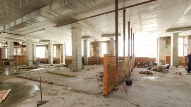 Panorama duvarları örmek için tuğla döşeyen duvarcıları gösteriyor. Profesyonel inşaat işçisi sanayi bölgesinde tuğla döşeyip bina inşa ediyor..