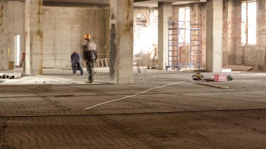 Construction workers with scaffolding and tools inside the floor of high rising building timelapse, skyscraper. Building under construction. Interior work in progress.