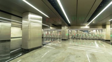 Turnike zaman aşımına uğramış, modern bir metro istasyonu. Giriş bölümünün metal ve mermer iç kısmı