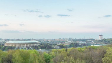 Moskova City, Rusya 'nın panoramik manzarası, gün batımından sonra Sparrow Hills' ten gece geçiş zamanına kadar. Luzhniki Stadyumu ve nehir üzerindeki köprü