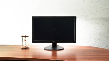Bilgisayarlı dijital bir iş için çalışma masası, monitörün yanında kum saati hiperlapse. Siyah ekrana hareket ettir