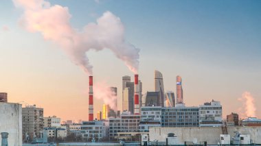 Moskova City gökdelenlerinin kış günbatımı zamanı bacaları duman yayıyor. Uluslararası İş Merkezi ve Moskova 'nın merkezindeki ticaret bölgesinin en üst görüntüsü, Rusya