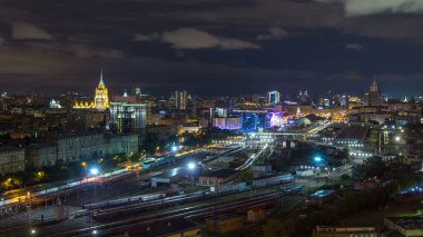 Rusya 'nın başkenti Moskova' da Kiev Tren İstasyonu 'nun gece vakti panoramik manzarası. Trenleri ve rayları olan bir çatı manzarası. Yukarıdan aydınlatılmış binalar