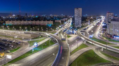 Road interchange of People Militia street, Mnevniki street and avenue Marshal Zhukov timelapse aerial top view in Moscow at night from rooftop. Traffic on the road with overpass junction clipart
