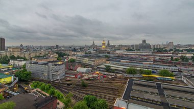 Moskova, Rusya 'daki Komsomolskaya meydanındaki üç tren istasyonunun gece gündüz geçiş zamanlarının en iyi görüntüsü. Çatıdan hava manzaralı bir yer. Trenler raylarda. Stalin gökdelenleri