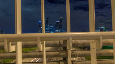 Gökdelenler ve ulaşım metropolü zaman atlaması, trafik ve trafik ışıkları Moskova 'daki çok şeritli otoyollarda ve gece yol kavşağında. Köprüden çitli hava görüntüsü