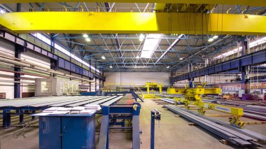 Factory workshop with lifting crane device timelapse hyperlapse, lift operator loads using lifting magnet, mechanical workshop, metal structures plant. Automated machine for precise metal cutting.