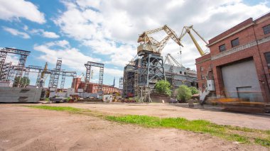 The construction of a large ship on a shipyard with cranes timelapse hyperlapse. A fragment of the case in the workshop of the plant. Metal frame during assembly